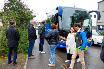 Personen steigen in wartenden Bus