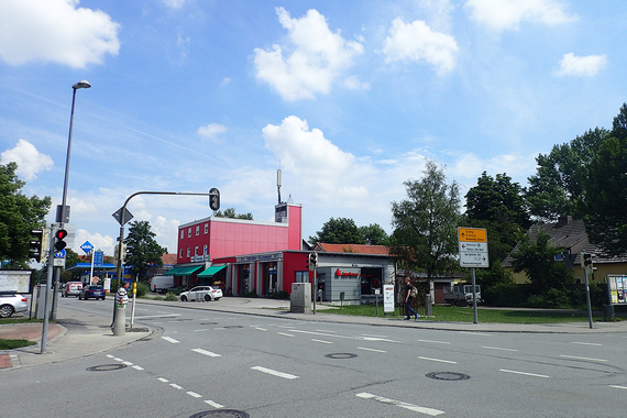 Eine Straßenkreuzung mit Ampeln, Autos, Fußgängern