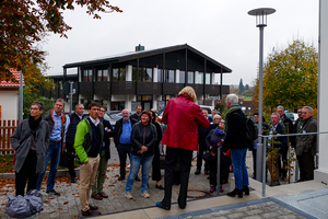 Eine Gruppe von Menschen steht vor dem Gebäude des Kirchenwirts.