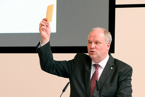 Person am Rednerpult mit Abstimmungskarte