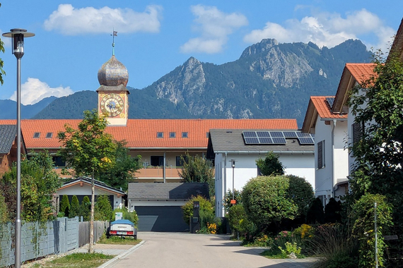 Wohnhäuser mit Alpen im Hintergrund