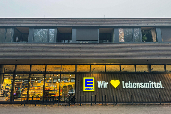 EDEKA Supermarkt unten mit Wohnungen oben, außen Holzfassade
