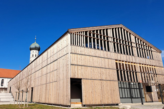 Großer Holzbau; Kirche im Hintergrund