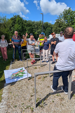 Menschen sind gruppiert um einen Stadtplan, der auf dem Boden liegt